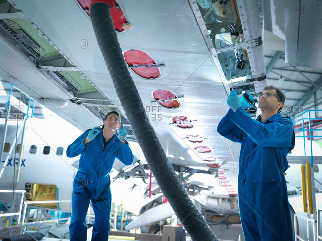 Engineers working on aircraft wing