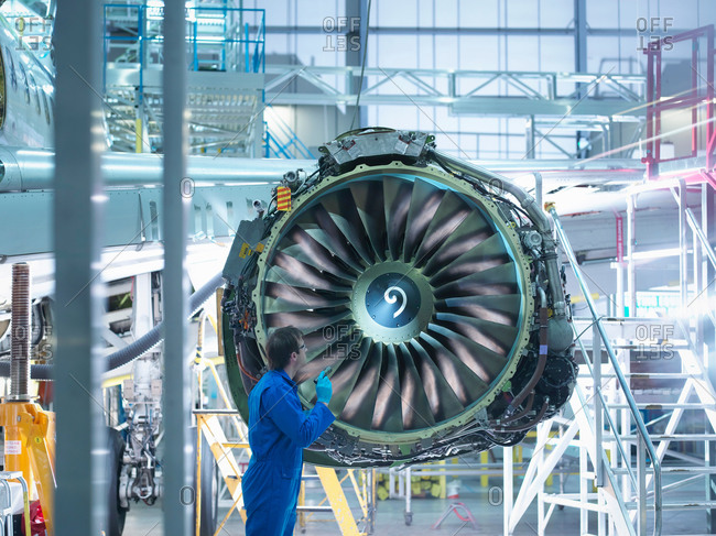 Engineer checking jet engine in aircraft maintenance factory