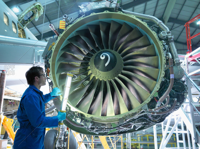 Engineer checking jet engine in airplane maintenance factory