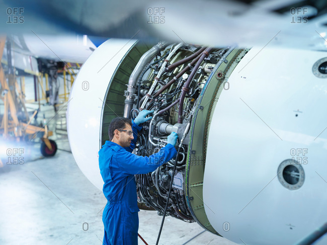 Engineer working on jet engine in aircraft maintenance factory