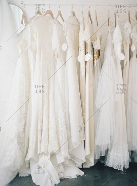 Variety of wedding gowns on a rack in a dress shop
