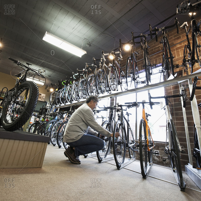 Pacific Islander man examining bicycles in bicycle shop