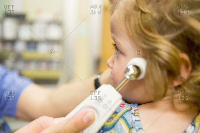 Close up of doctor taking temperature of boy with thermometer
