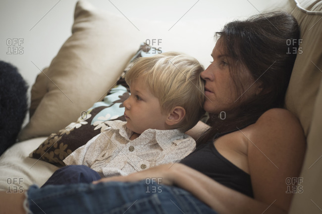 Caucasian mother and son watching television