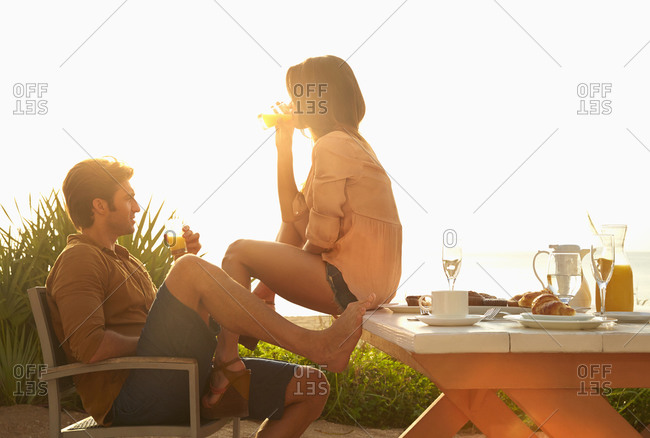 Hispanic couple relaxing at table outdoors
