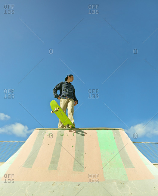 Caucasian man standing on skateboard at skate park