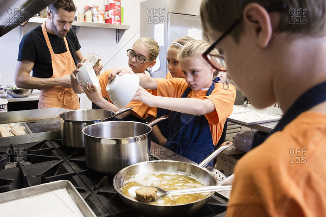 Teacher and students cooking in class