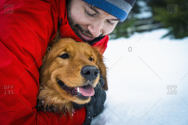 Man hugging dog in winter