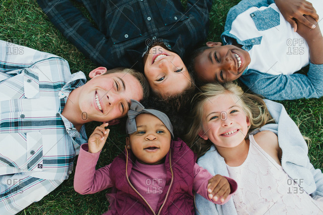 Overhead view of blended family lying in the grass