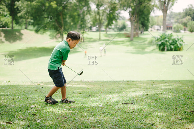 Little boy practicing golf