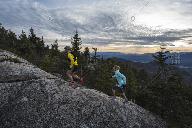 Trail runners heading up the steep and open granite slabs near the summit of Black Cap mt