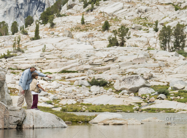 Father teaching son to fly fish at High Sierra lake, John Muir Wilderness Area, High Sierra