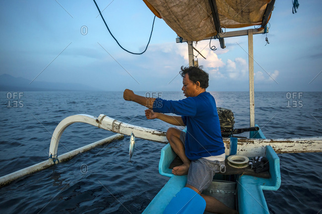 Balinese traditional fisherman with a fish on his line