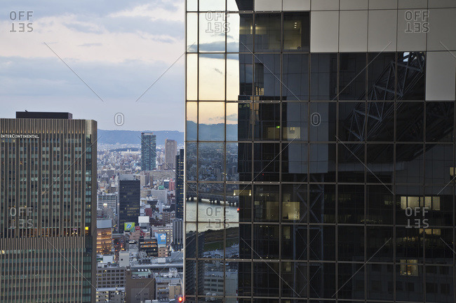 Office building with glass walls reflecting other buildings; Osaka, Japan