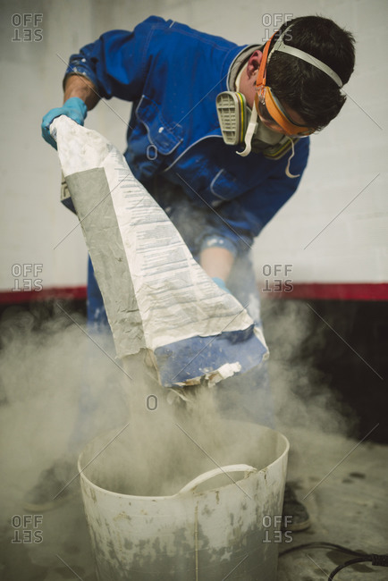 Bricklayer pouring cement powder in bucket