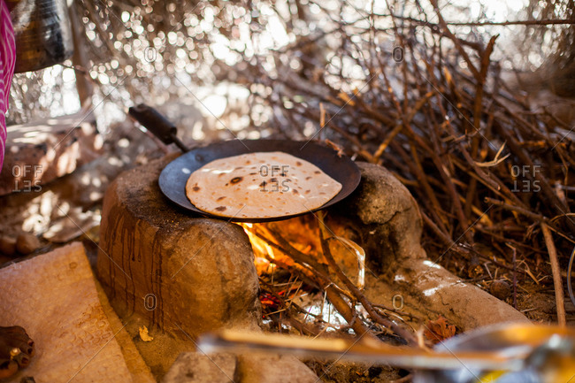 Flat bread baking on pan over a wood fire