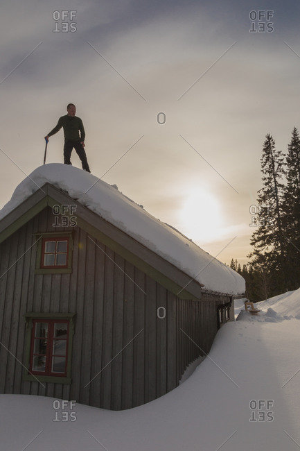 Man on roof with snow shovel