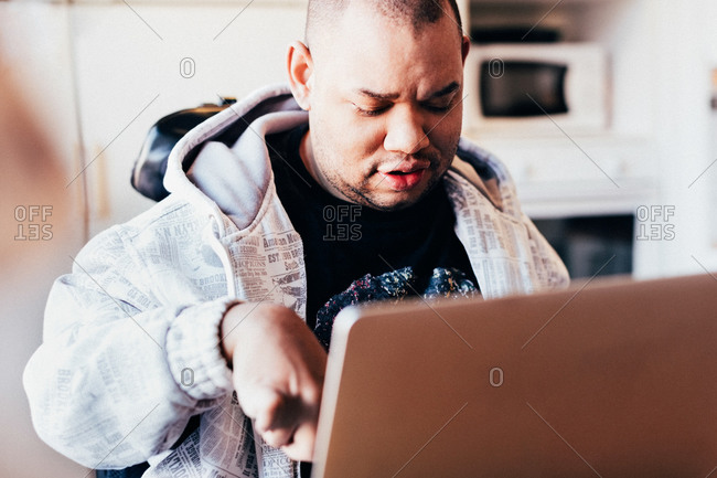 Disabled man using laptop in recording studio