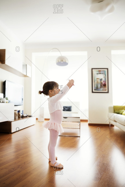 Side view of girl performing ballet dance at home