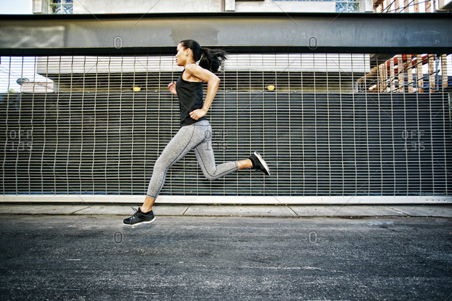 Mixed race athlete running on street