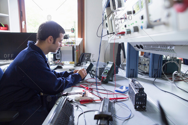 Male electrician repairing electronic equipment in workshop