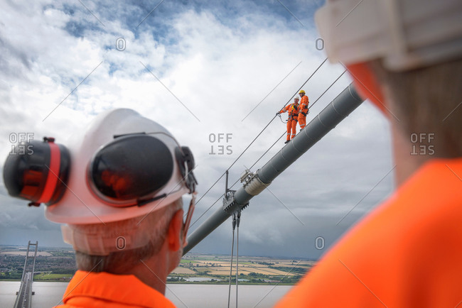 Bridge workers working on cable of suspension bridge