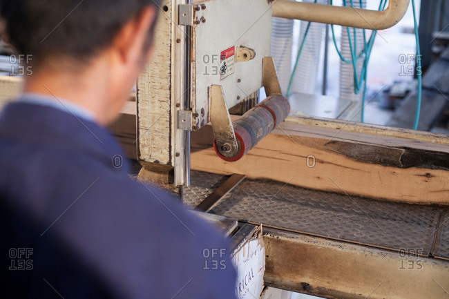 Carpenter working on wood flooring machine in factory, Jiangsu, China