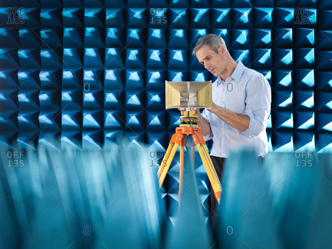 Scientist preparing to measure electromagnetic waves in anechoic chamber