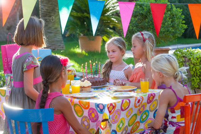 Girl with friends at table with birthday cake