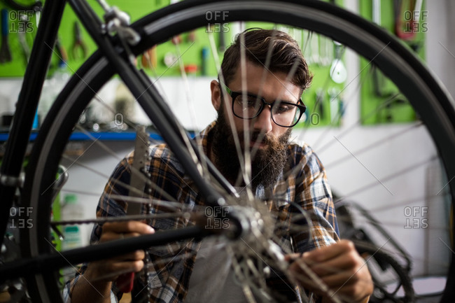 Bike mechanic checking at bicycle in bike repair shop