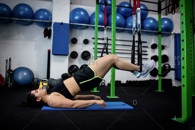 Woman doing suspension training with fitness straps at gym