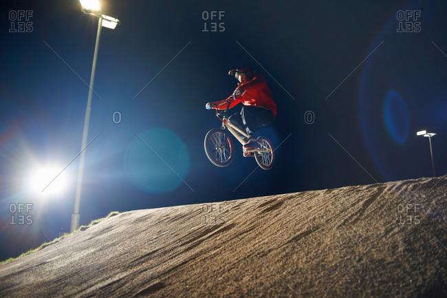 BMX-cyclist jumps his bike at night time