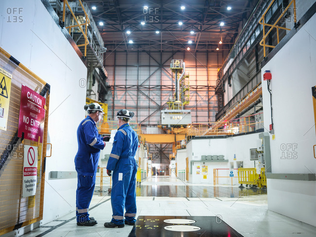 Engineers in discussion in reactor hall in nuclear power station