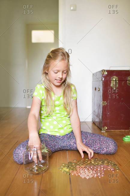 Girl counting coins from savings jar