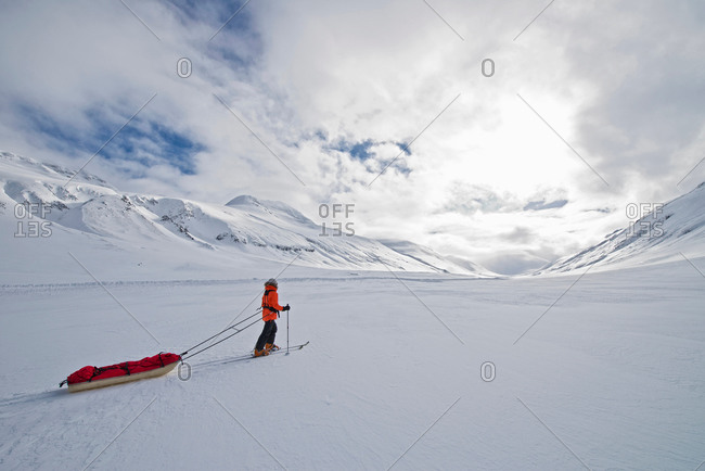 Female touring skier pulling expedition sled in snow, Oxnadalsheidi, North Iceland, Iceland