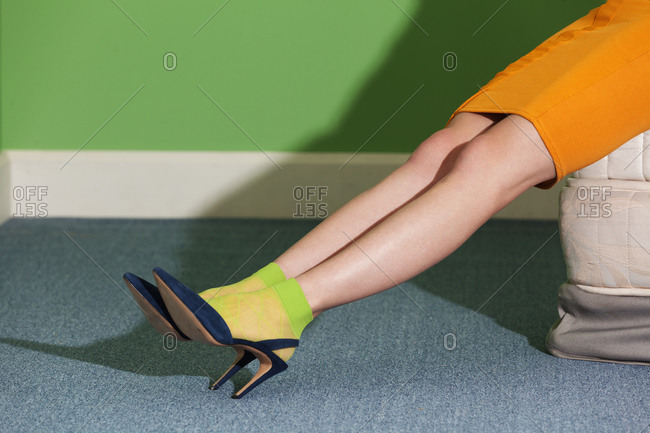 Legs of a woman wearing high heels and green socks