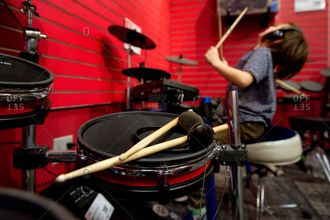 Boy playing drums in a music store