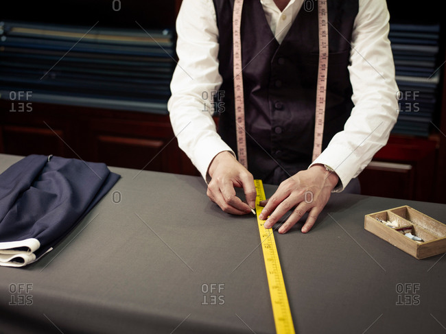 Tailor chalking measurements in traditional tailors shop