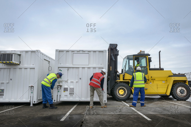Emergency Response Team workers installing emergency control rooms with fork lift truck