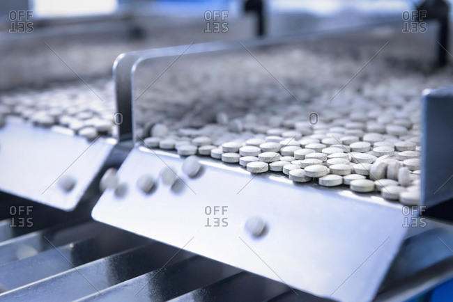 Close up of tablets in packing machine in pharmaceutical factory