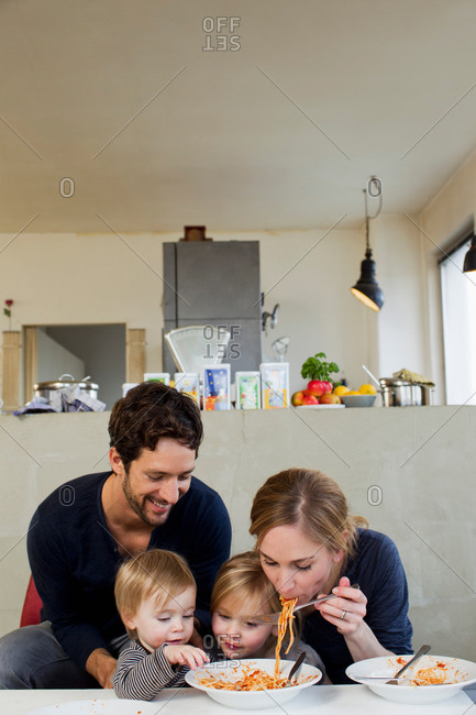 Family with two daughters eating spaghetti meal