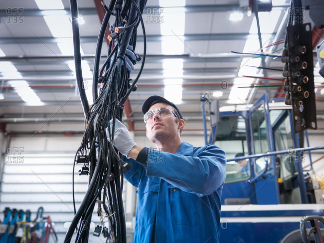 Engineer installing new electrics in truck repair factory