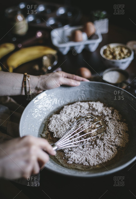 Woman whisking dry ingredients for banana bread donuts