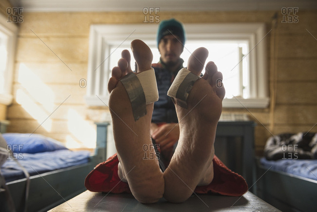 Make-shift bandages on heavily blistered feet after hiking, Lapland, Sweden