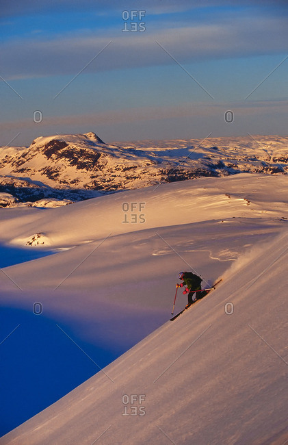 Skier skiing a steep descent on Appusuit Glacier near Maniitsoq, Greenland