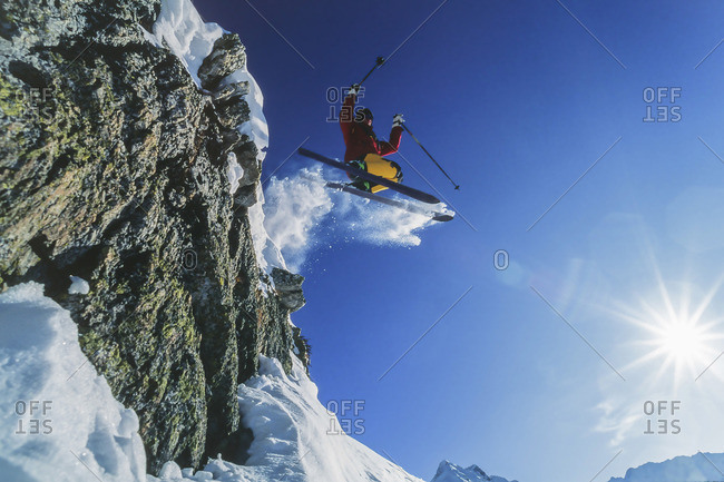 Skier skiing off a snowy precipice at St. Anton am Arlberg, Austria