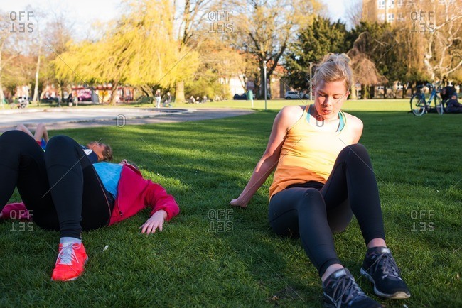 Women sitting on the grass resting after a workout