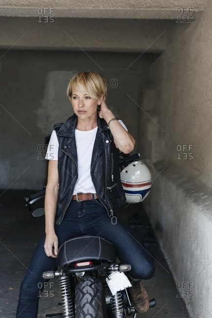 Woman sitting on a motorcycle in a garage