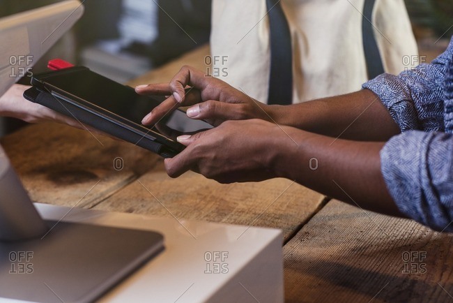Customer and store owner using a digital tablet for a point of sale transaction