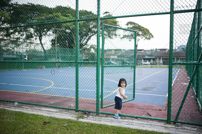 Toddler walking on to an athletic court at a local park